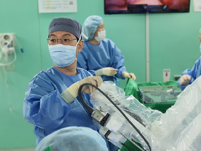 건양대병원 산부인과 김철중 교수가 로봇수술 집도를 위해 로봇 팔을 환자의 수술 부위에 도킹하고 있는 모습.