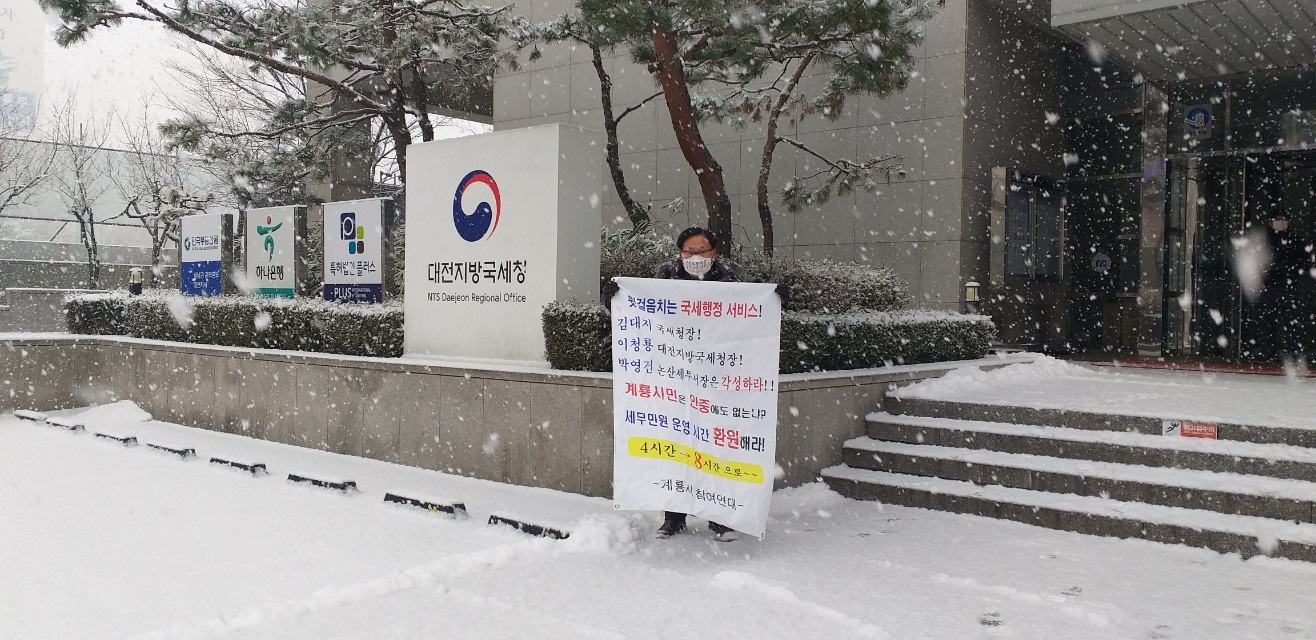 18일 폭설이 내리고 있는 가운데 대전지방국세청 청사 입구에서 1인 시위에 나선 이종각 계룡시 참여연대 대표